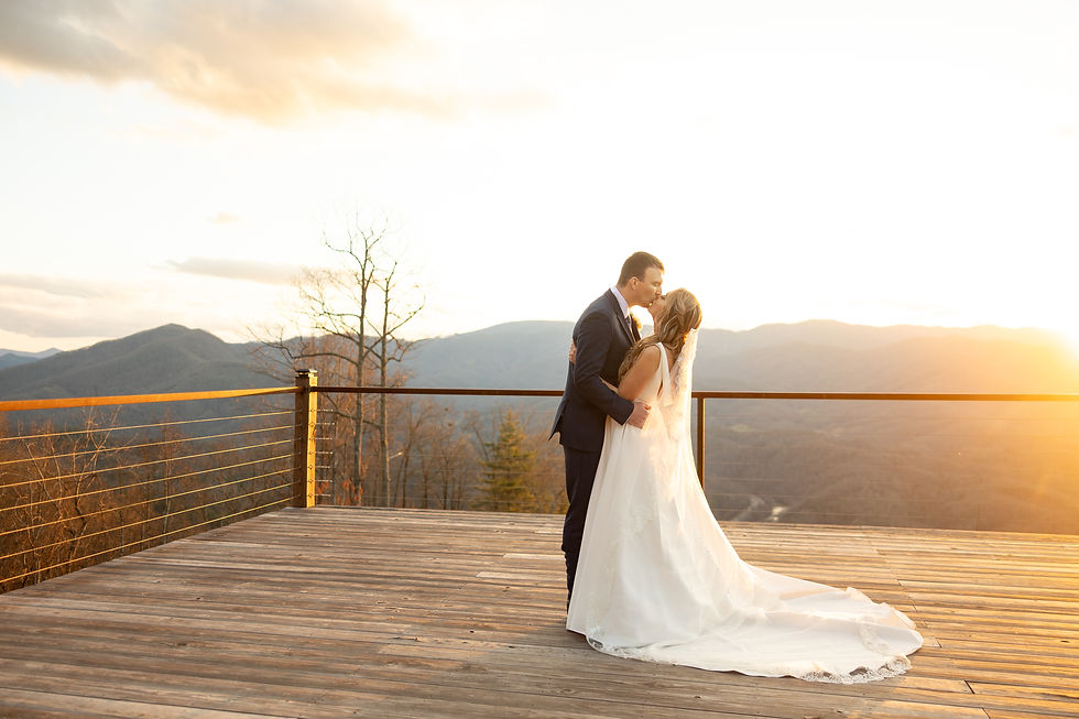 The bride and groom kissing during golden hour in the mountains.