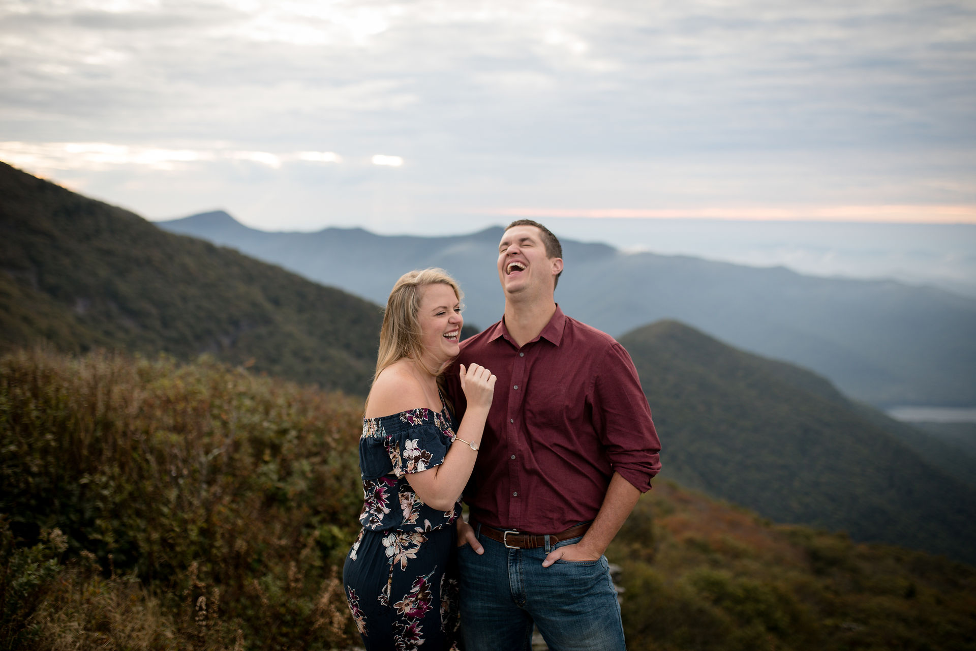 engaged couple laughing together in the blue ridge mountains 