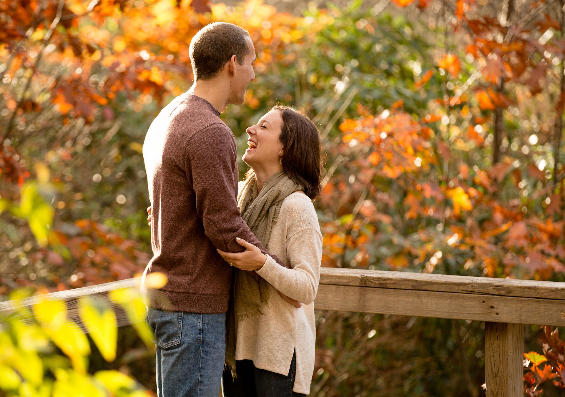 engaged couple holding each other closely and laughing 