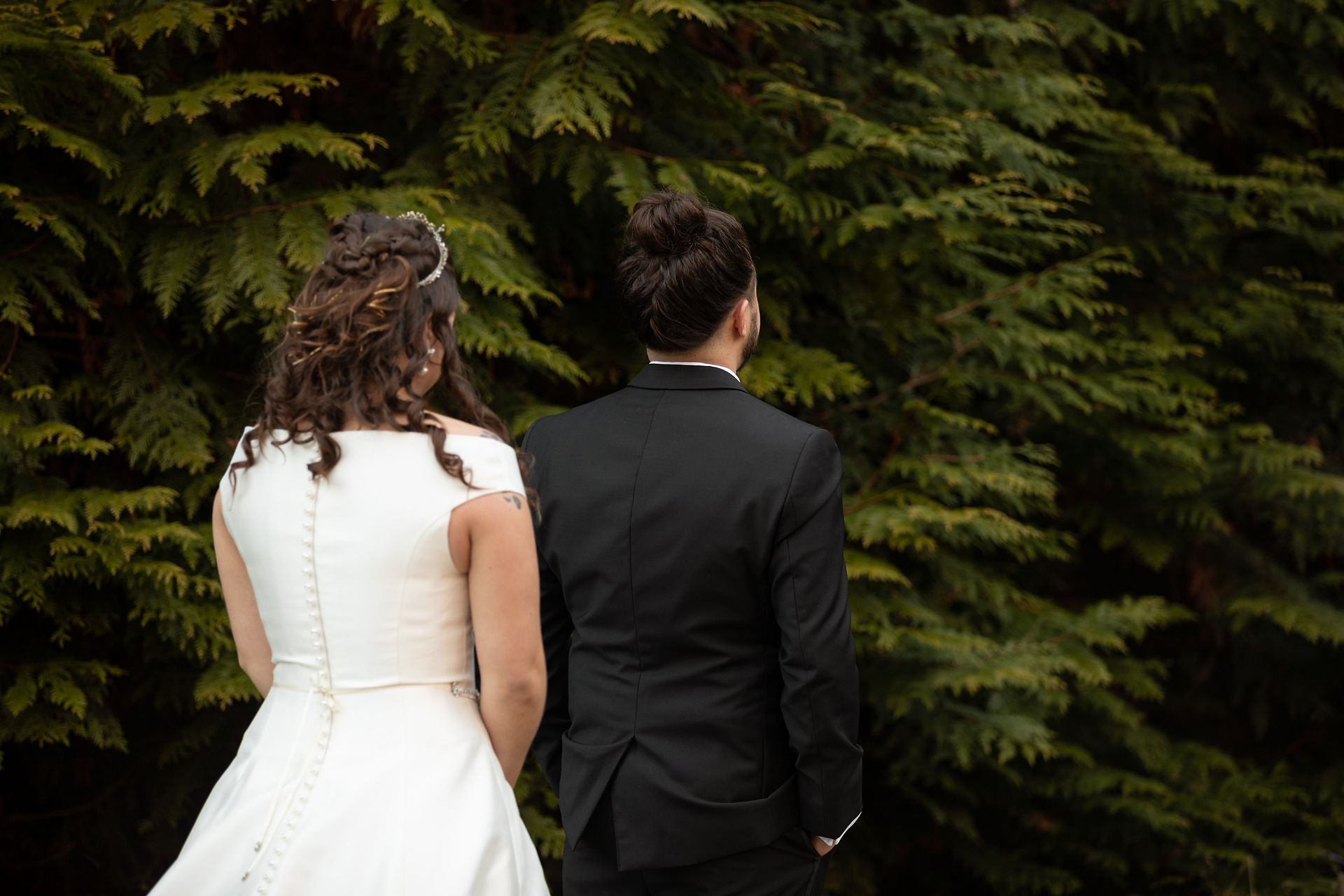 bride standing behind the groom 