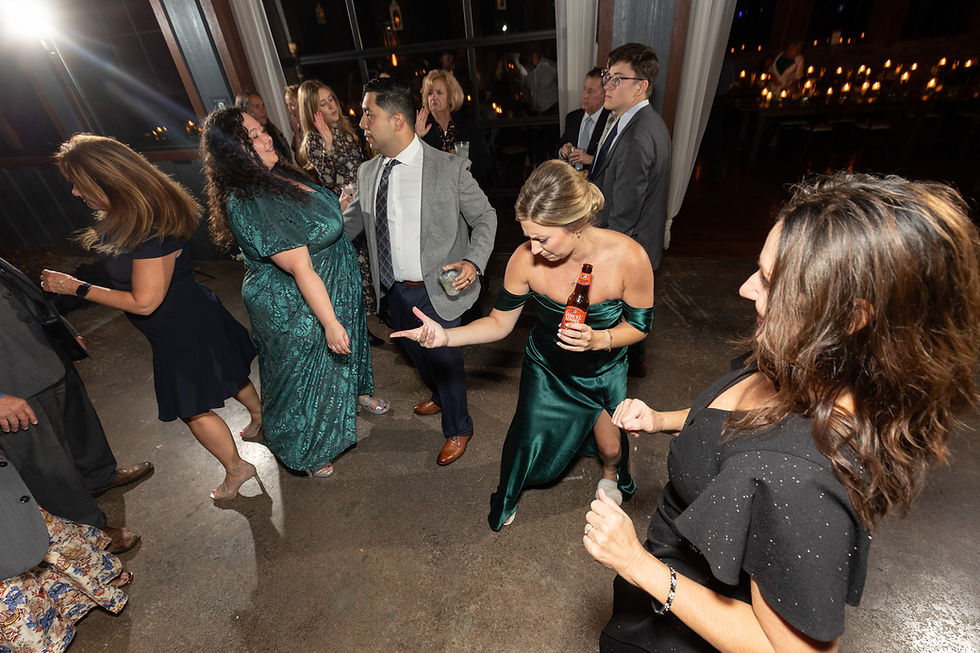 A bridesmaid plays air guitar as she dances on the dance floor.