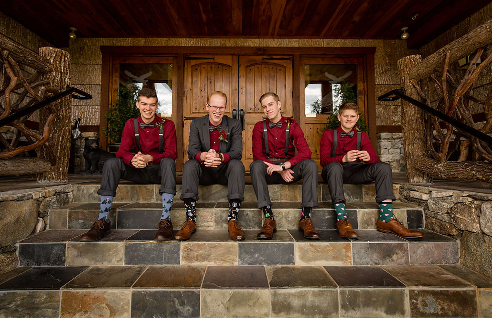 groom and groomsmen sitting on stairs and smiling
