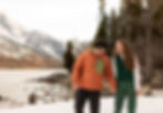 a couple laughing as they hold hands and walk
