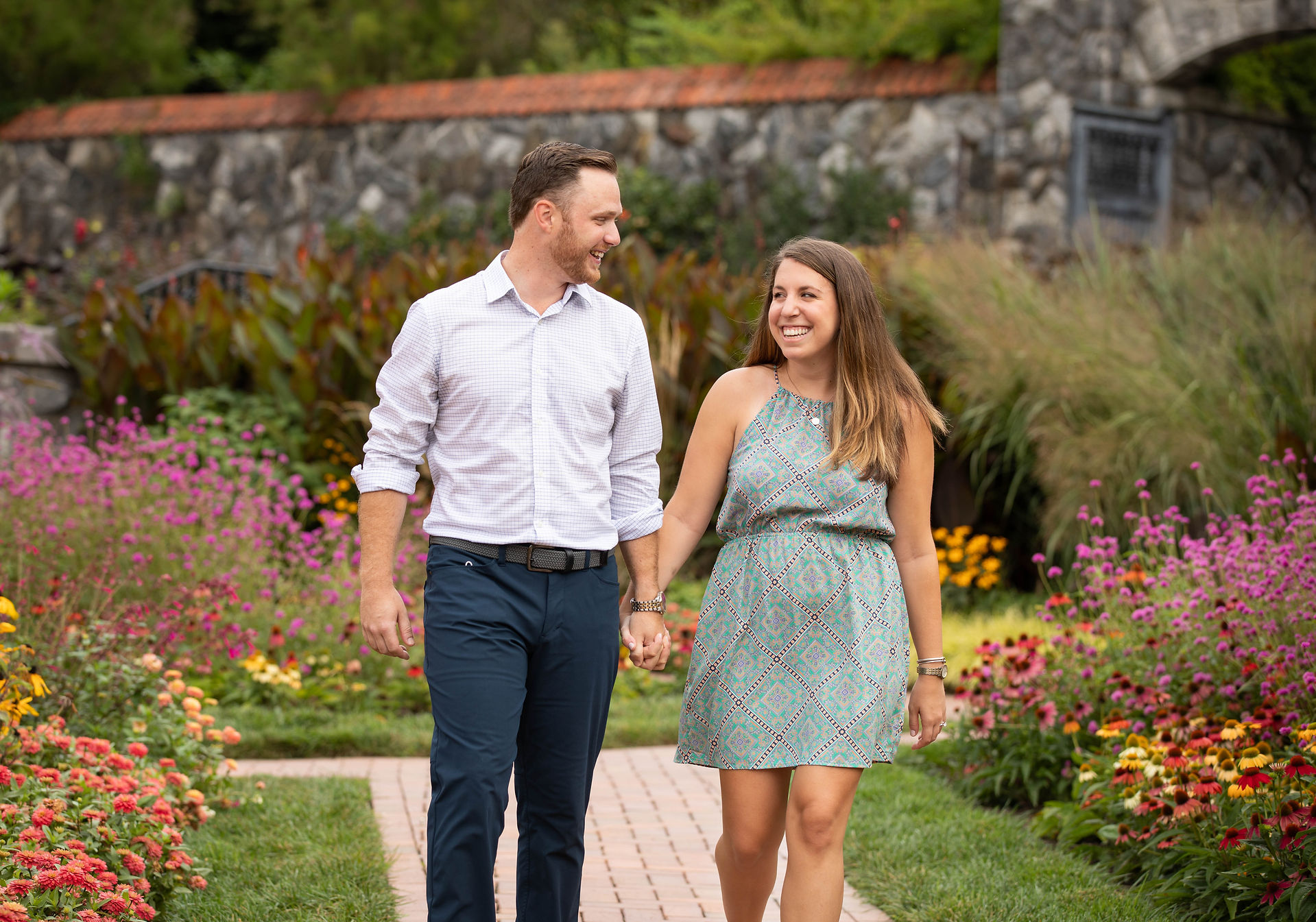 couple smiling at each other as they walk through the gardens at the biltmore 