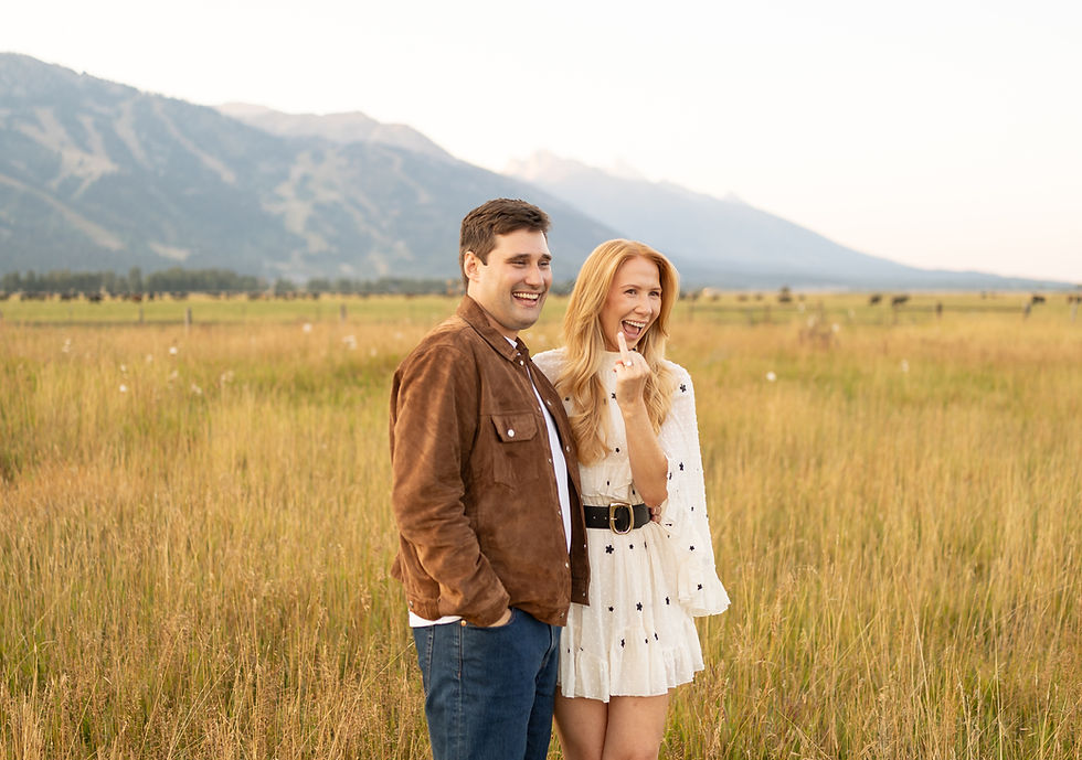 A newly engaged couple smiling as they show off the engagement ring.