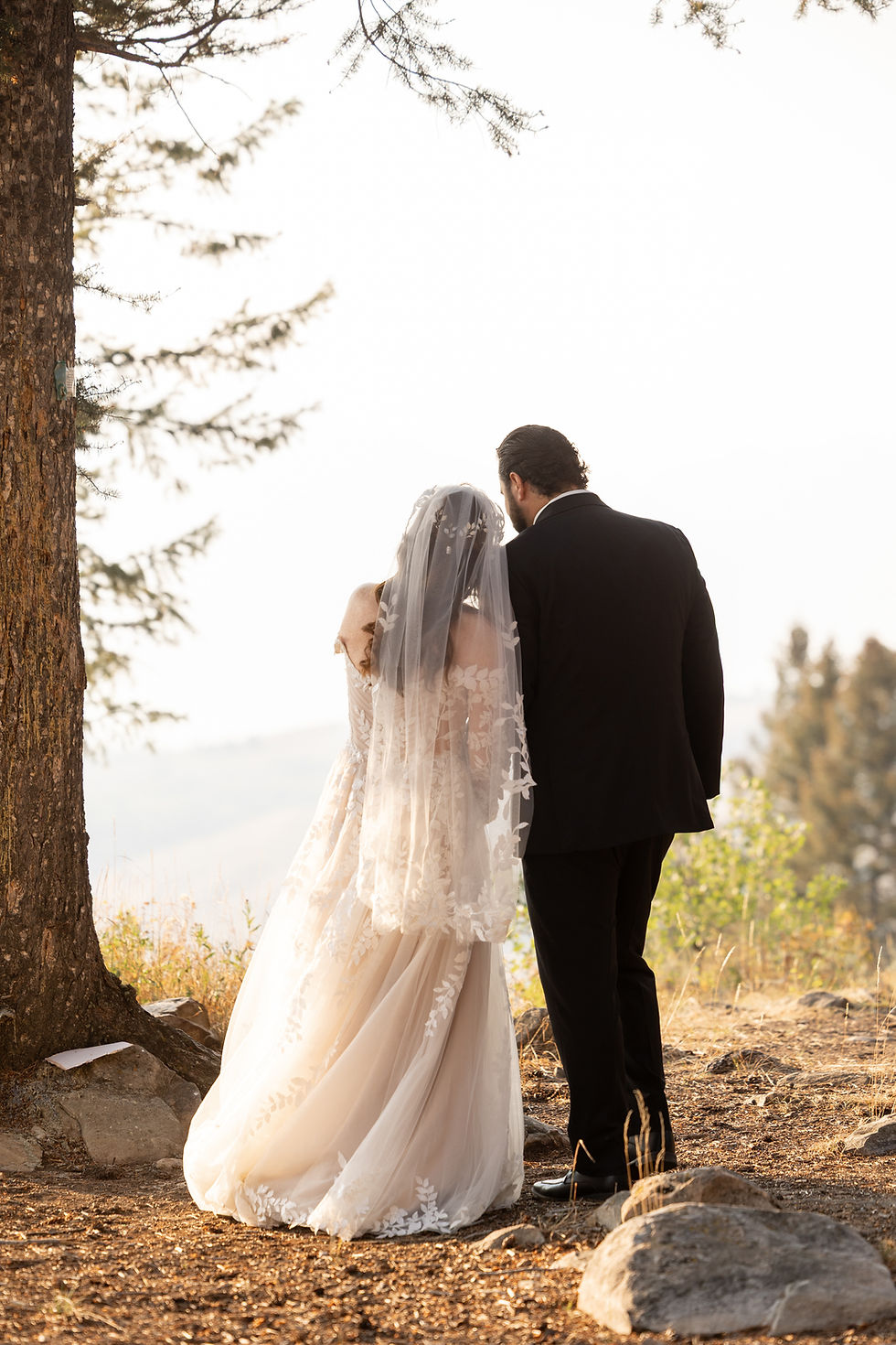 The bride and groom sharing an intimate moment, shortly after their first look. The bride wraps around his arm and lays her head softly on his shoulder.
