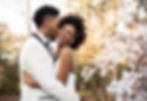 groom kissing bride on the cheek in front of cherry blossoms