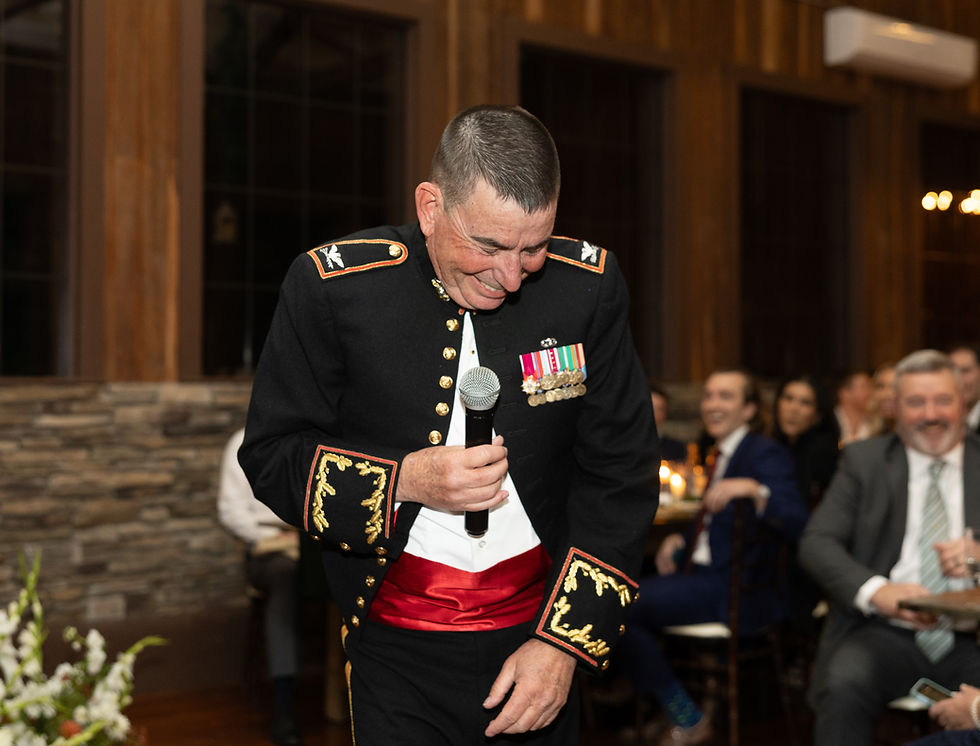 The father of the bride laughing as he gives his toast.