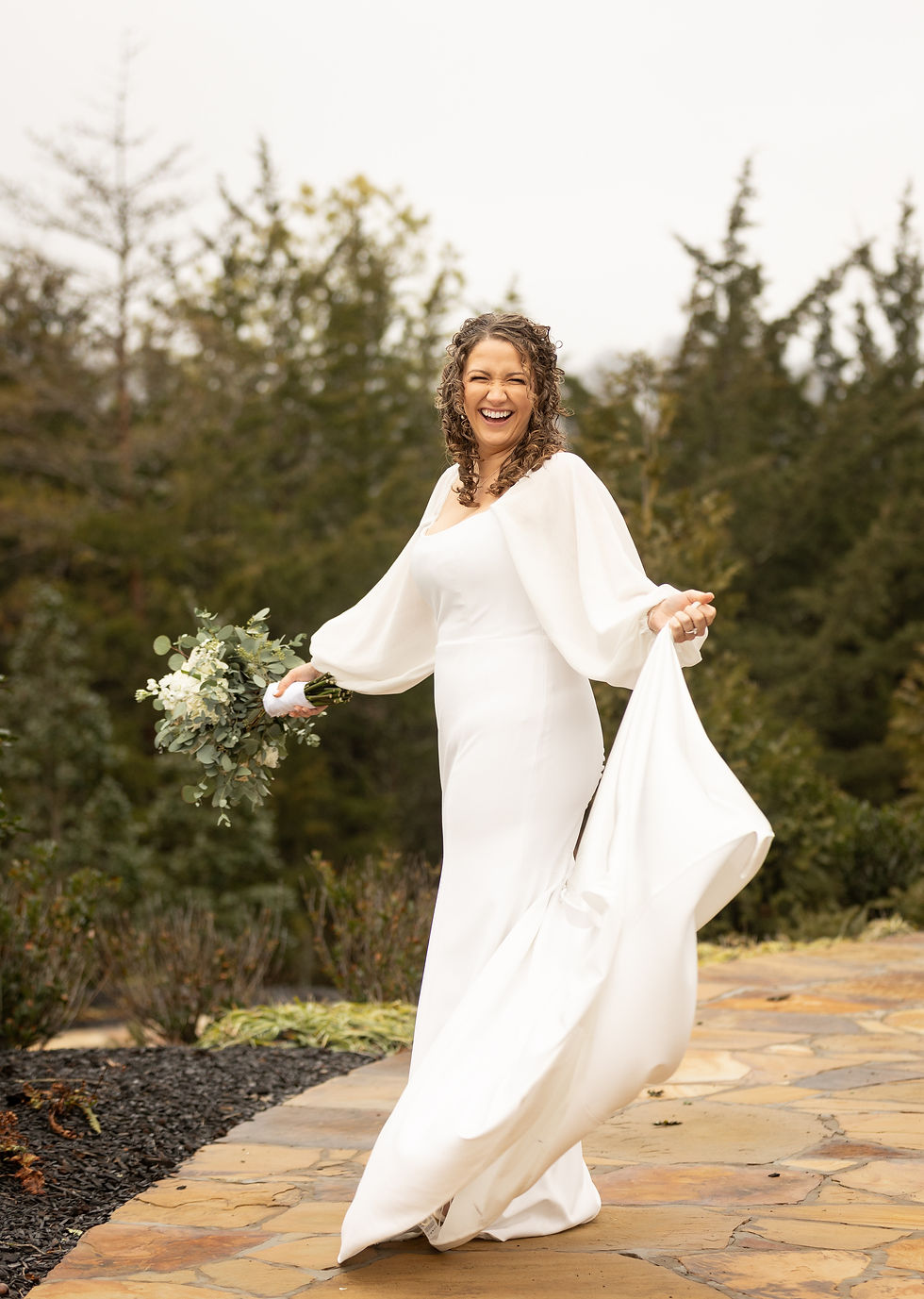 The bride laughing as she spins in her dress.