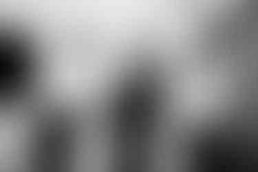 groom laughing as his dad and brother help him get ready