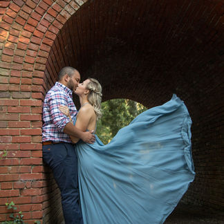 woman's dress floating as she kisses her fiance 