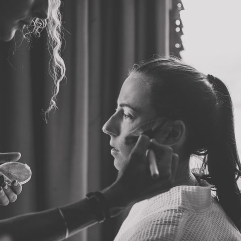 make up artist brushing the bride's cheek
