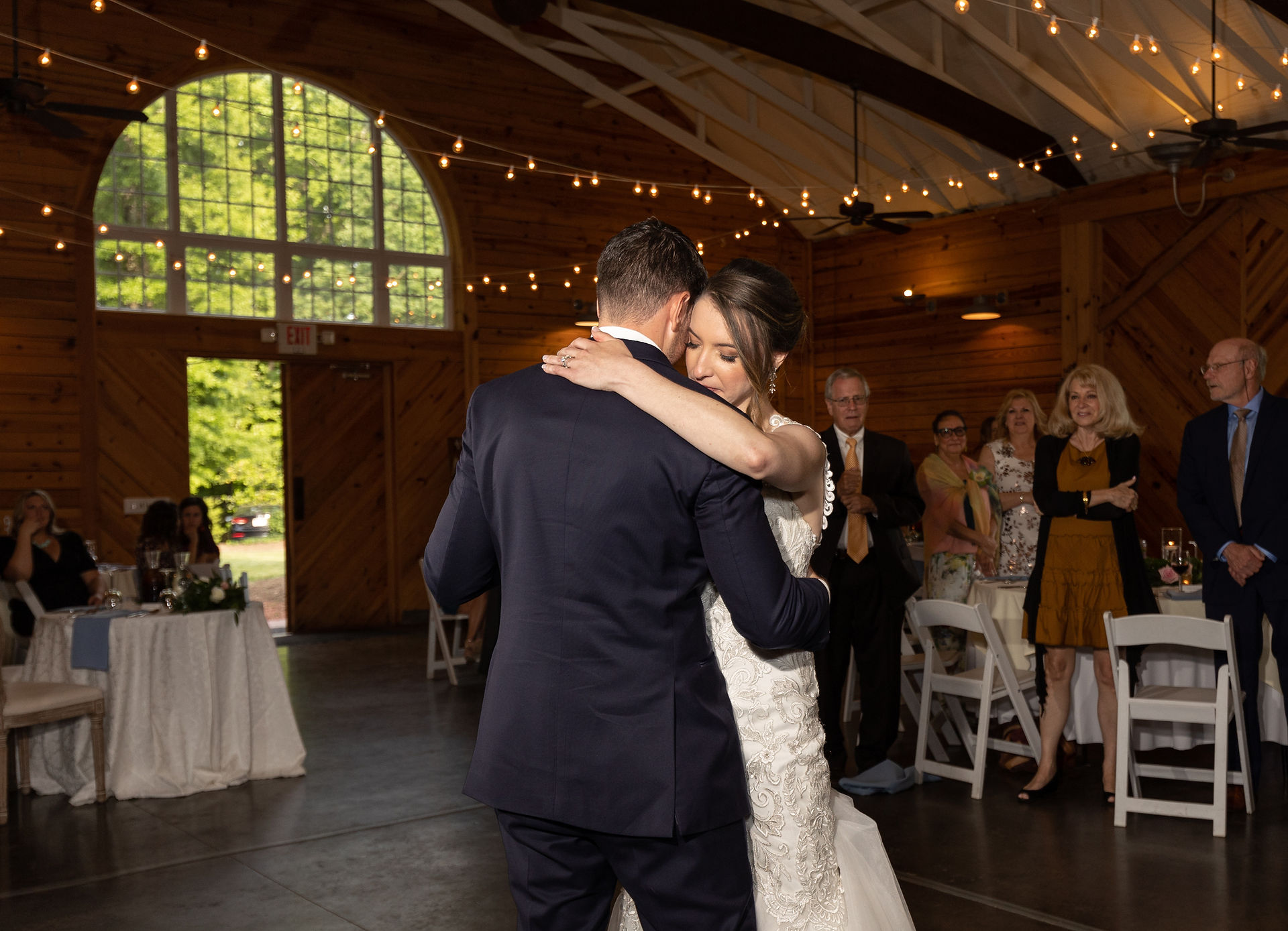 bride holding groom tightly during their first dance 
