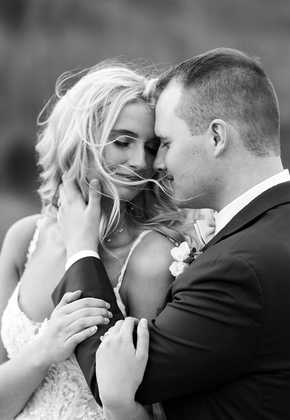 The groom and bride sharing an intimate moment as the wind blows.
