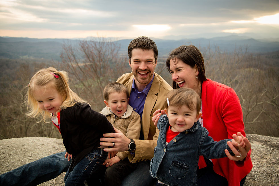 family of five sitting together and laughing
