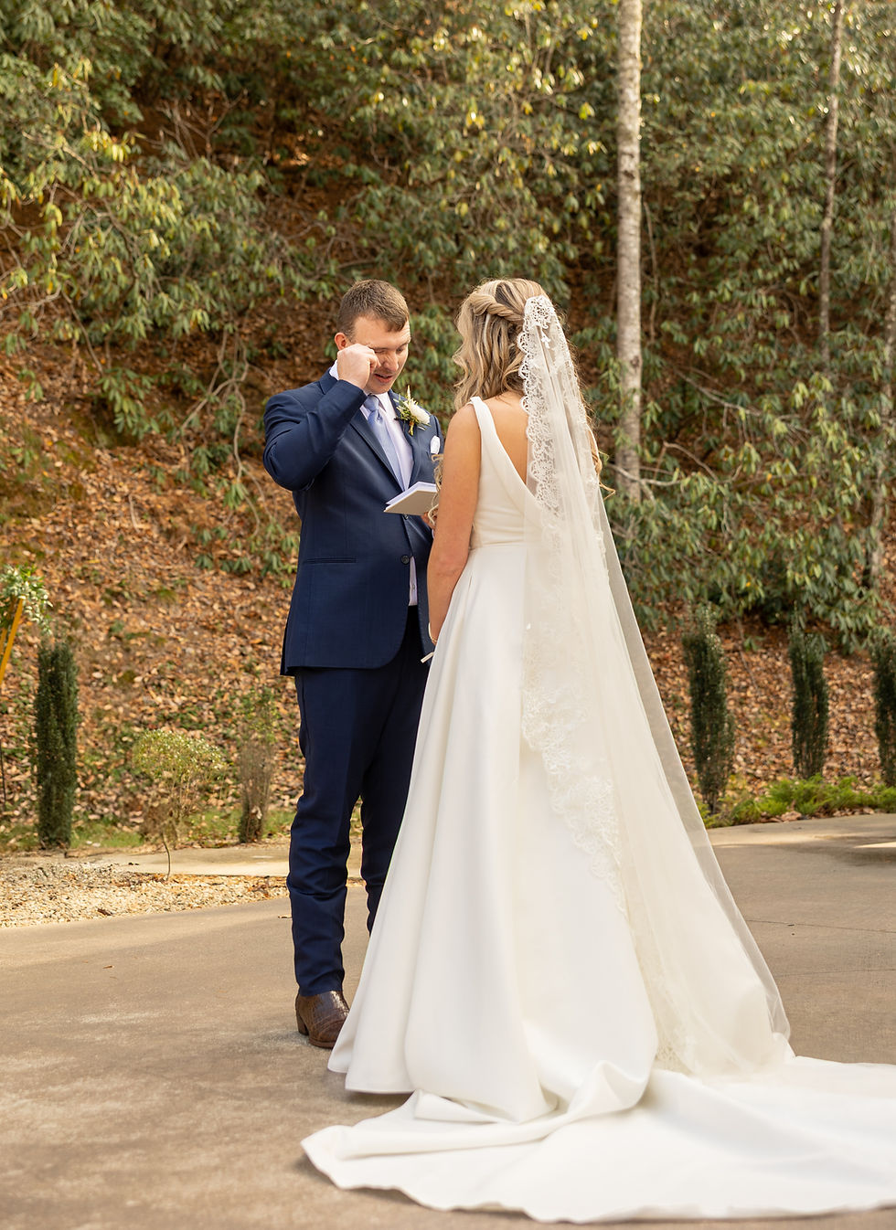 The groom wipes away tears as he reads his vows.