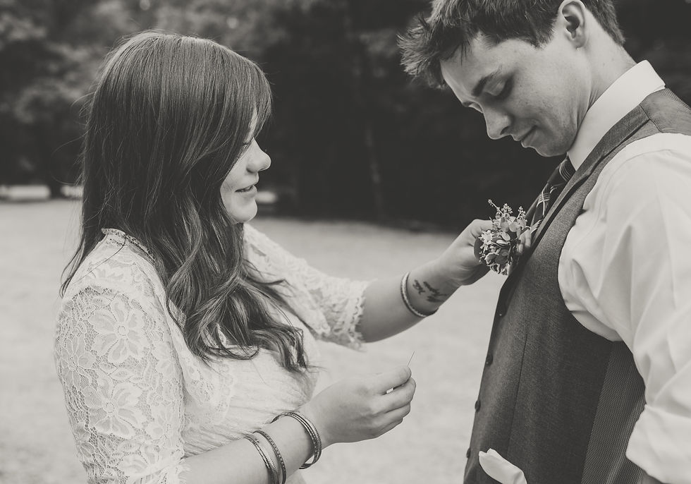 bride adjusting the groom's boutonniere