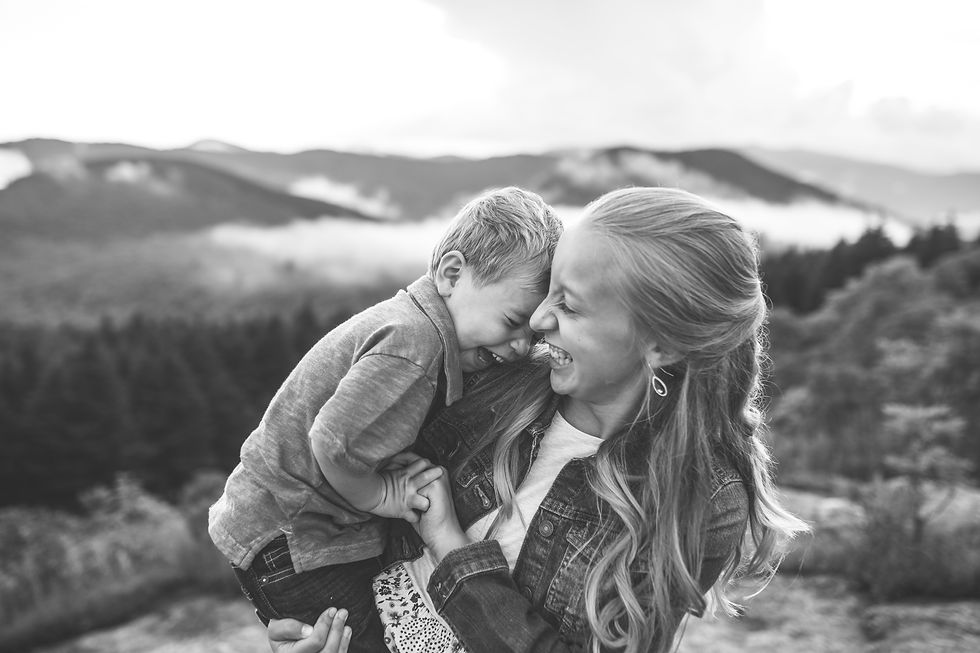 a little boy laughing as his sister tickles him