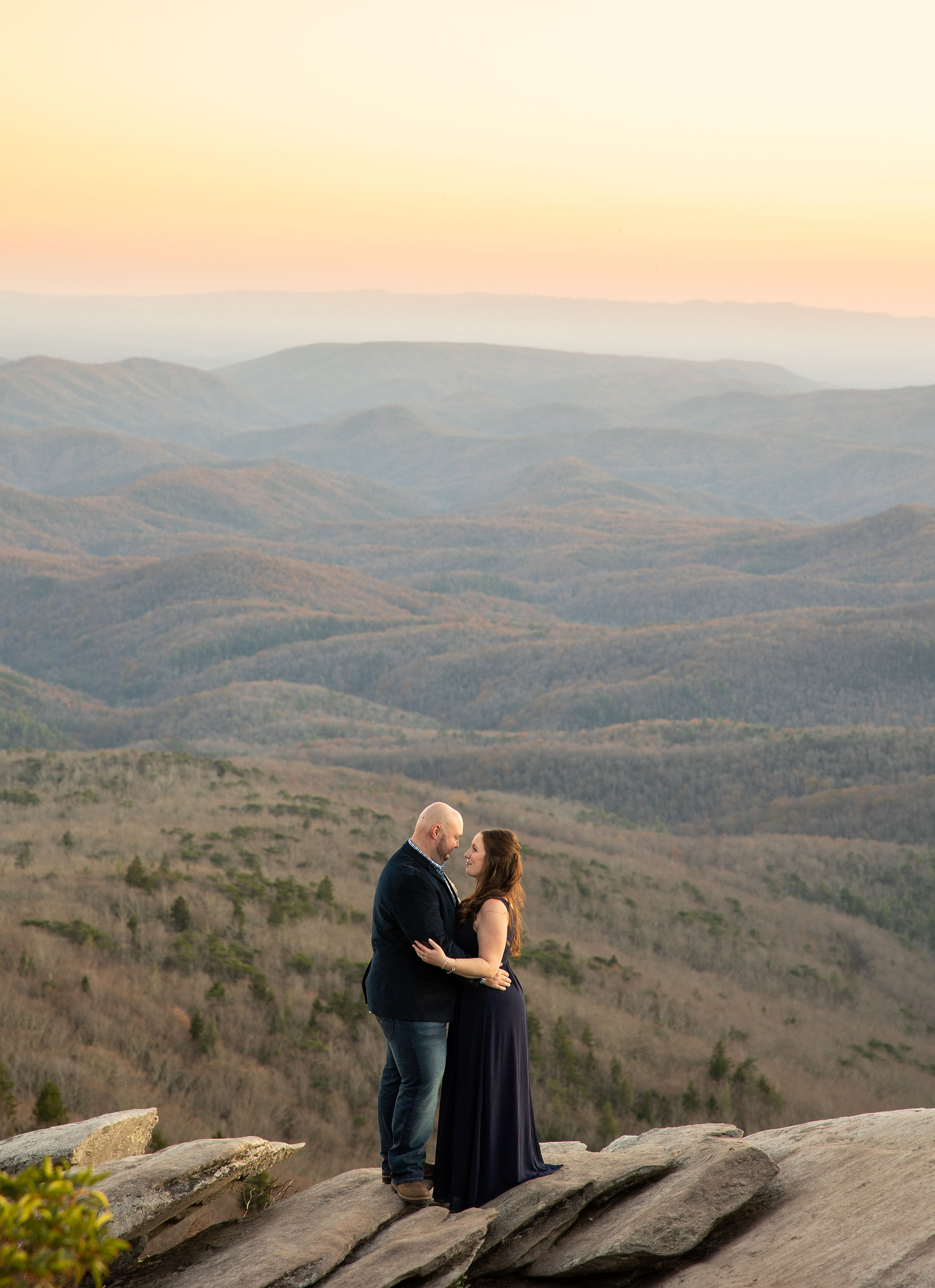 A couple kisses during golden hour in the blue ridge mountains.