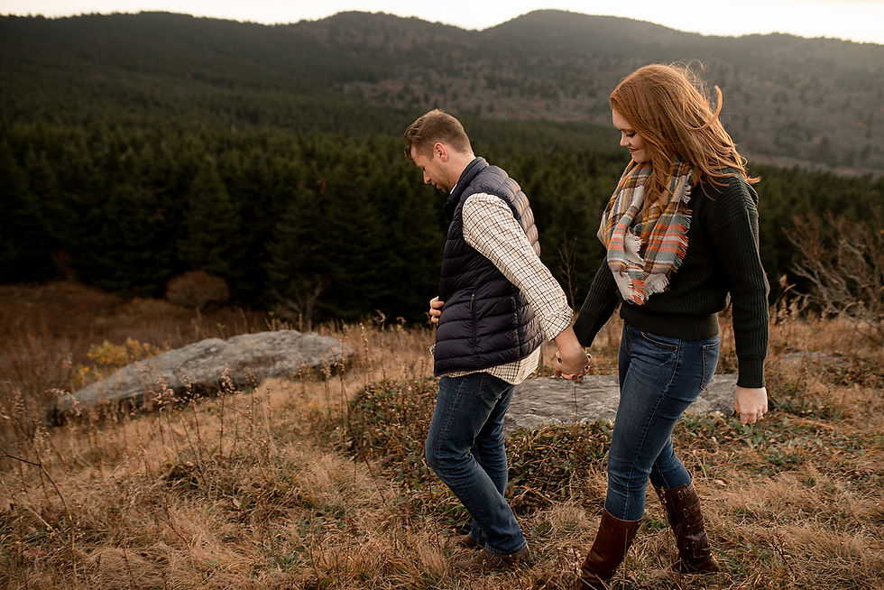 engaged couple holding hands and hiking through the mountains