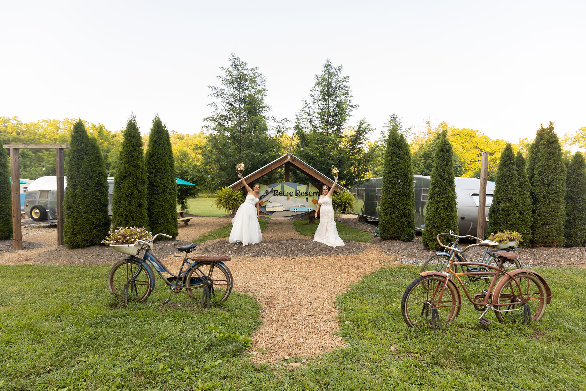bride's raising their flowers in front of venue sign