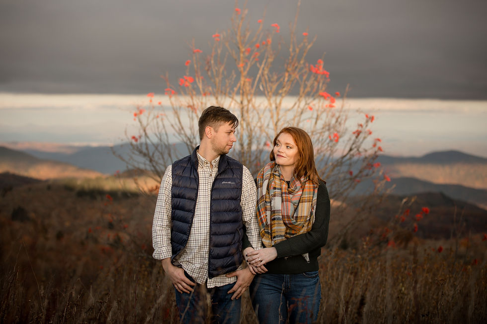 woman wrapped around her fiance's arm in front of a flowering tree