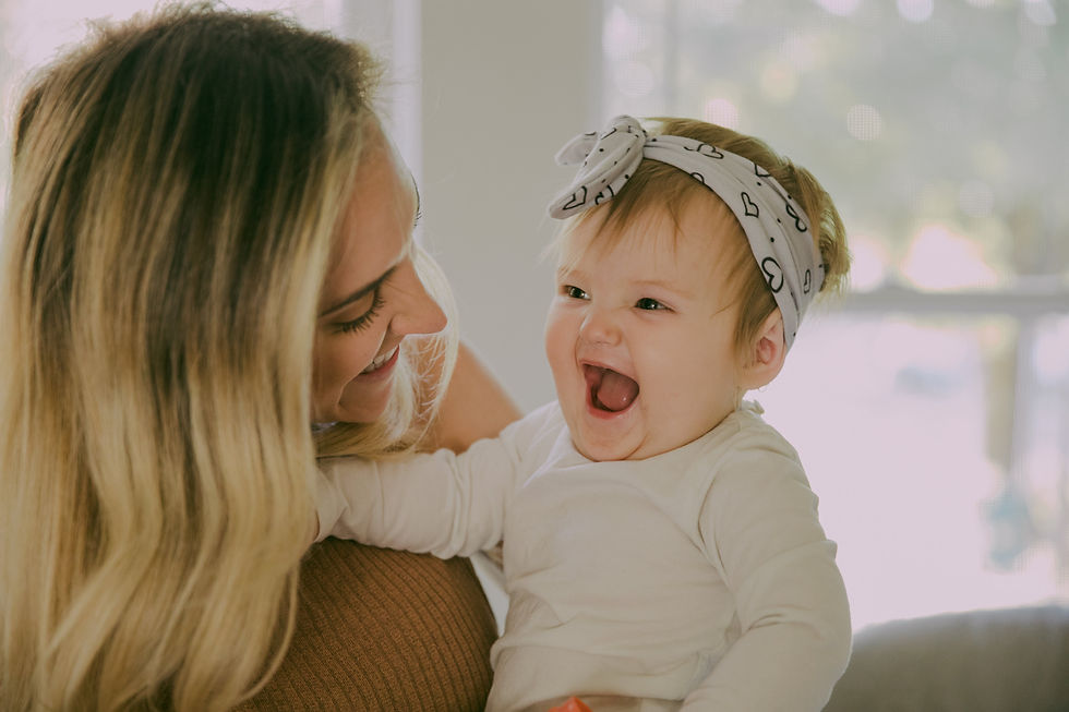 a baby laughing as her mom plays with her