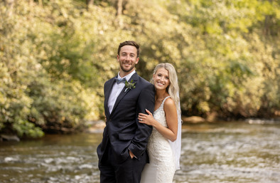 bride and groom smiling as bride holds groom from behind