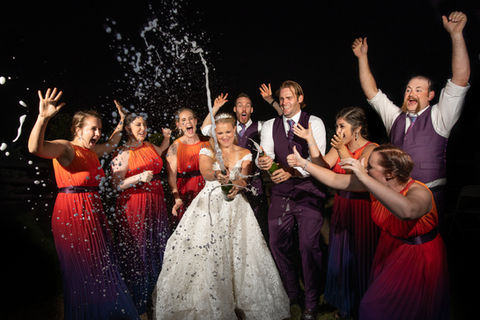 Bride and Groom Popping a bottle of champagne 