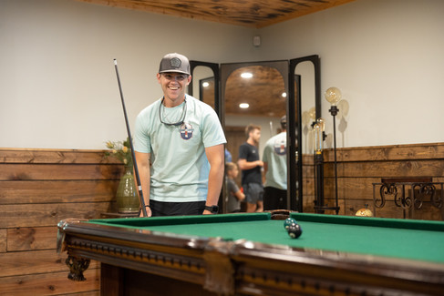 groomsman laughing while playing billiards