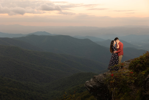 Dramatic sunset portrait of a woman caressing her fiance's face.