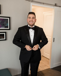 groom buttoning his jacket 