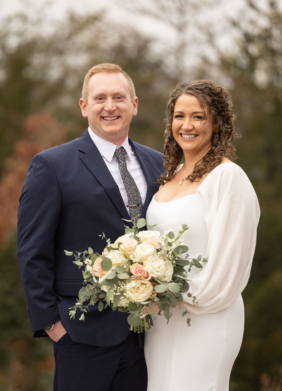 Traditional portrait of the bride and groom smiling.