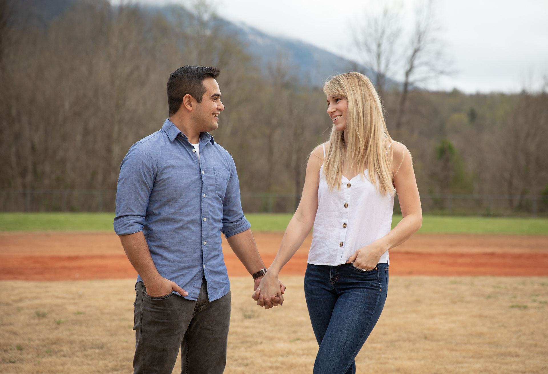 couple standing side by side and holding hands 