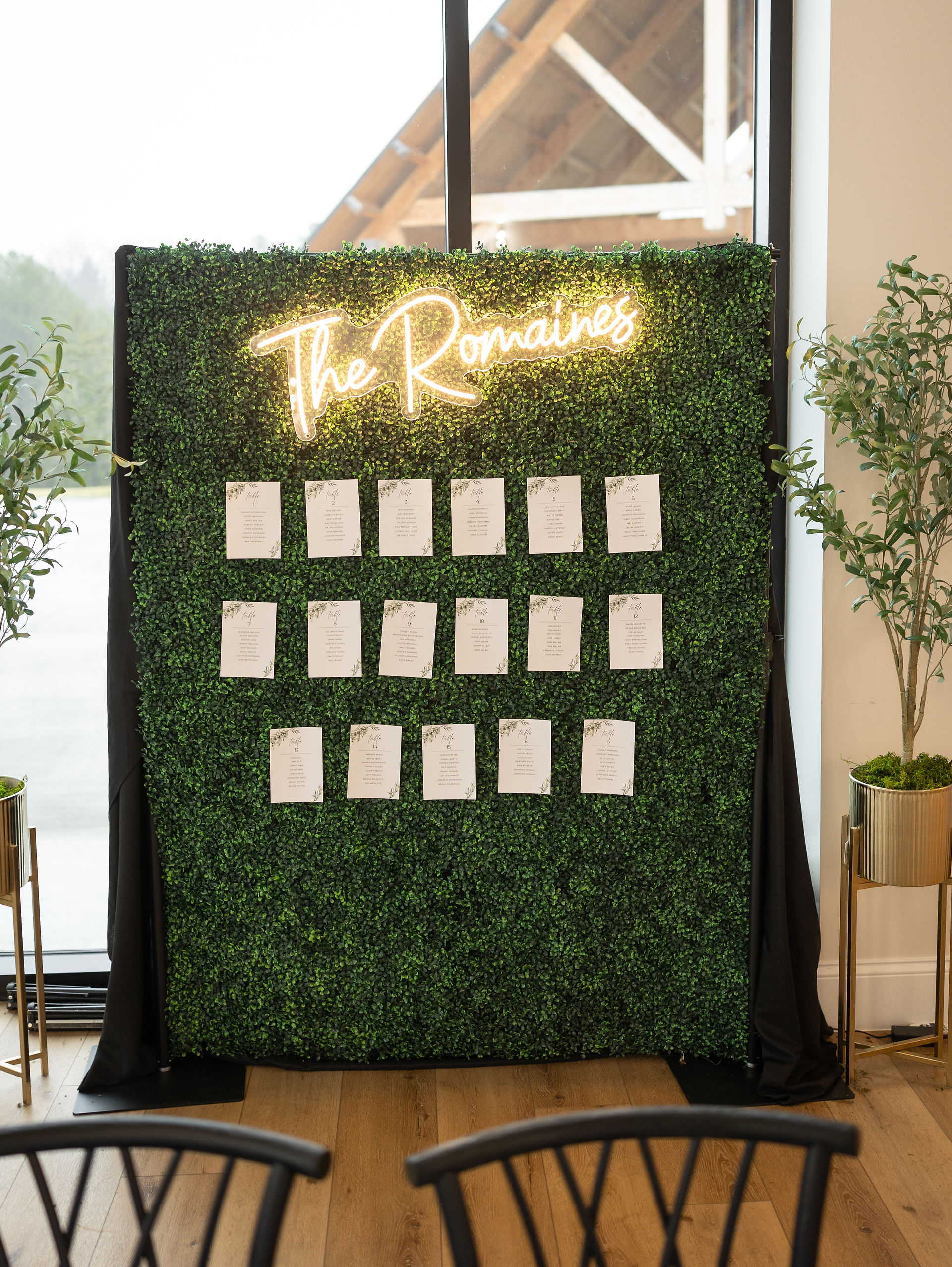 Wedding seating chart on a greenery wall