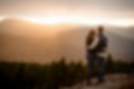 engaged couple holding each other and watching the sunset