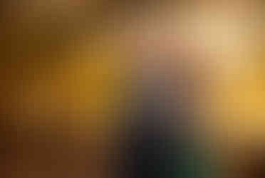 A man laughs as his fiance hugs him from behind. 