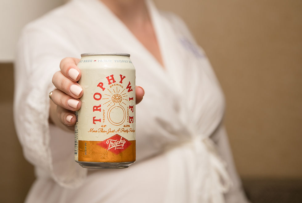 bride's hand holding a beer that says trophy wife