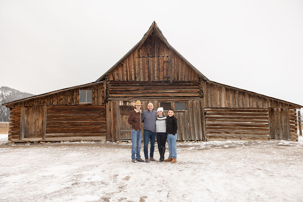 family portrait in front of the ta moutlon barn
