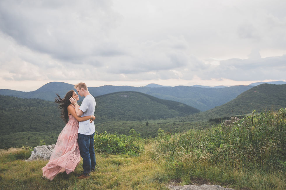 man caressing his fiance's face in the windswept mountains