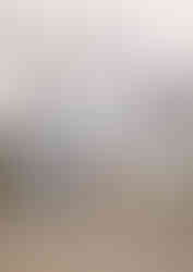 A bride and groom kiss in the middle of a road that looks like it leads right to the mountains in the background that are covered in snow.