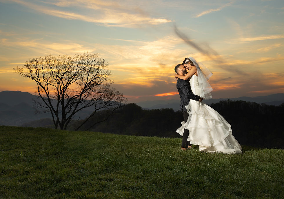 groom picking up bride during sunset