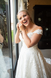 bride smiling while putting her earrings on