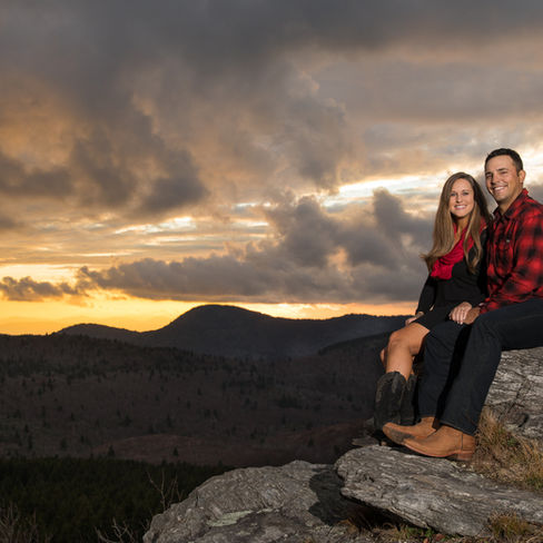 traditional portrait of a couple sitting in the mountains