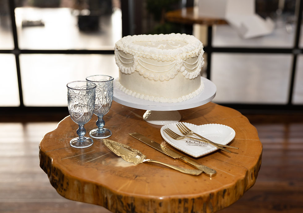 Wedding Cake and antique silverware sitting on a cocktail table.