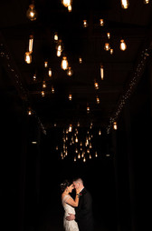 dramatic night time portrait of the bride and groom under the lights 