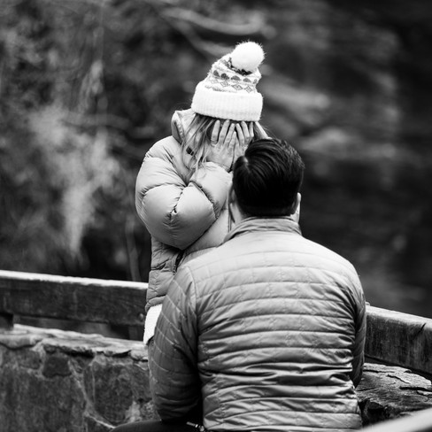 woman covering her face during a surprise proposal