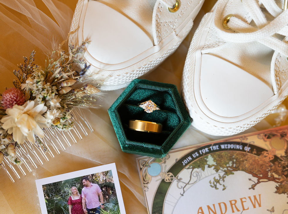 Bridal details in a lay flat showing all of the bridal details such as the white wedding shoes, jewelry and natural floral hair piece.