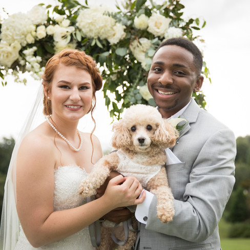 bride and groom smiling with their poodle