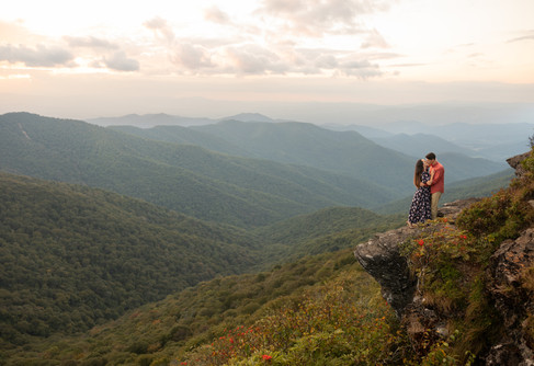 A couple kisses on the edge of a cliff at craggy gardens.
